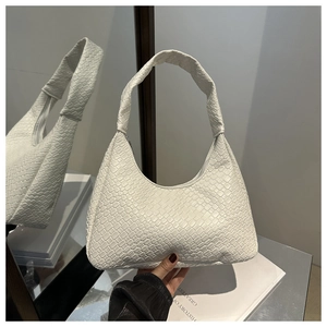 Detailed close-up of white woven texture on a minimalist crescent hobo handbag