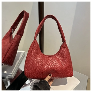 Detail of red woven leather hobo bag featuring premium texture and top zipper closure
