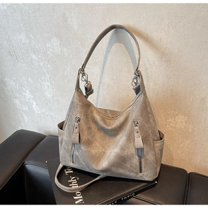 Detailed view of taupe hobo bag with vintage texture, side pockets, and dual strap design