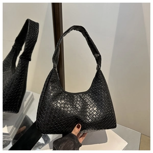 Close-up of black woven crescent bag featuring glossy PU leather and intricate grid texture