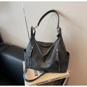 Close-up of matte grey hobo bag showing vertical zippers and high-quality texture