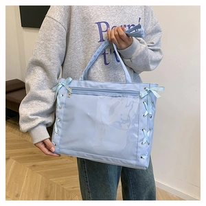 Dettaglio borsa tote azzurra con finestra in PVC trasparente e intrecci di nastri