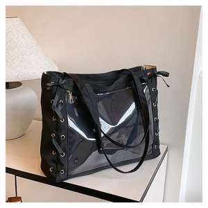 Dettaglio borsa tote in tela nera con finestra in PVC e lacci decorativi laterali