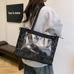 Borsa tote nera minimalista con pannello trasparente e fiocco mostrata su una modella