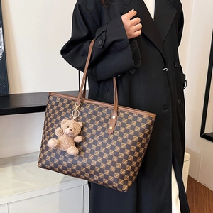 Large checkered tote bag in brown with plush bear pendant shown on shoulder
