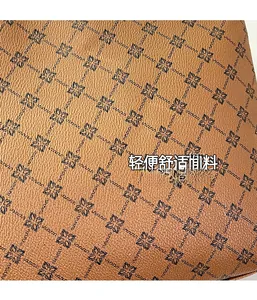 Close-up of brown textured leather with black floral clover pattern and pebble grain detail