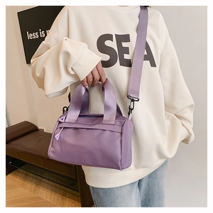Detail der lila wasserdichten Nylon-Minibag mit breitem Webriemen und Doppeltragegriffen