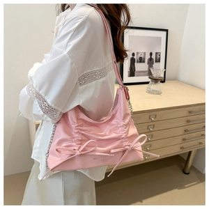 Pink pleated tote bag detail showing delicate ribbon bows and silver metal chain strap