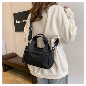 Minimalistische schwarze Umhängetasche aus Nylon mit verstellbarem Riemen am Model