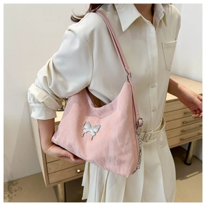 Gros plan détaillé d'un sac hobo rose en tissu avec une boucle papillon en métal argenté