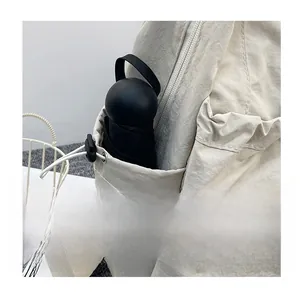 Detail of backpack side pocket with elastic drawstring holding a compact umbrella