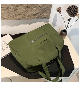 Detail of army green nylon tote bag with crinkled texture in an artistic setting
