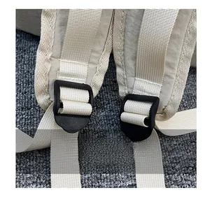 Detail of adjustable off-white backpack shoulder straps with durable black buckle sliders