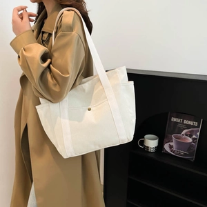 Minimalist cream canvas tote bag with front metal buckle pocket for daily commuting