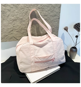 Close-up of pale pink large travel tote bag with durable nylon fabric and dual handles