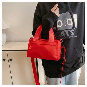 Detailansicht der roten Nylon-Zylindertasche mit passendem Gurt und Reißverschluss