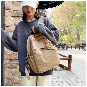 Detail of khaki outdoor backpack featuring drawstring closure and durable nylon fabric