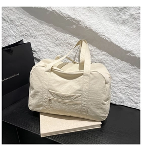 Close-up of lightweight pleated nylon tote bag with front zipper and top handle