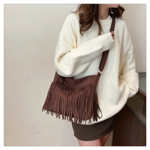 Dettaglio di una borsa tote in pelle scamosciata marrone con lunghe nappe a frange