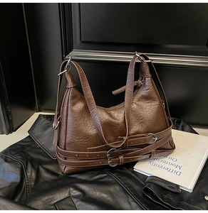 Detailed close-up of dark brown vintage faux leather tote bag with buckle straps and texture