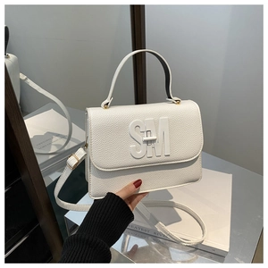 Détail d'un sac à main en cuir blanc avec logo SM en relief et bandoulière réglable