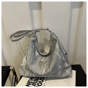Gros plan d'un sac cabas argenté métallisé avec texture plissée et détail de papillon
