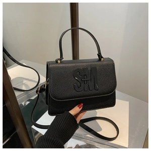 Détail du sac à main en cuir grainé noir avec logo SM et bandoulière amovible