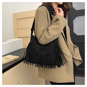 Modella che indossa una borsa tote in pelle scamosciata nera con frange lunghe