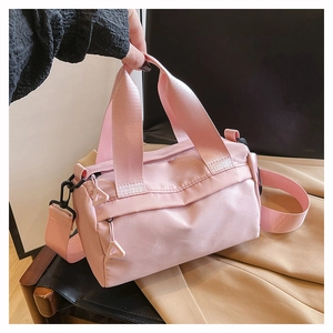 Detailansicht der pinken Mini-Umhängetasche aus Nylon mit Reißverschluss und Anhänger