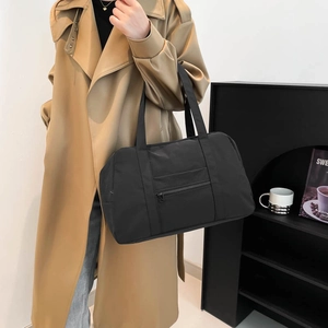 Minimalist black large capacity nylon tote bag shown in a stylish lifestyle setting