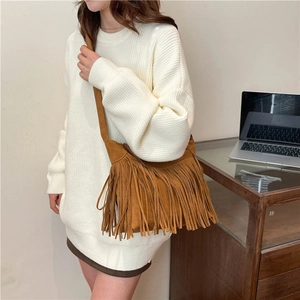 Borsa tote marrone con frange in finta pelle scamosciata indossata su un maglione bianco