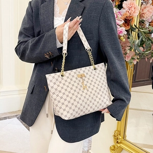 Vintage tote bag with geometric patterns, gold chain handles, and giraffe charm detail
