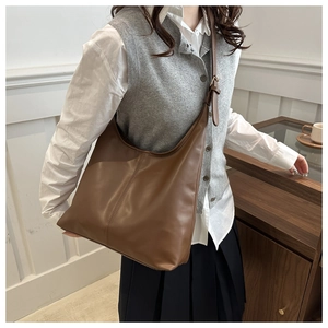 Dettaglio della texture in pelle sintetica marrone e cuciture verticali sulla borsa tote