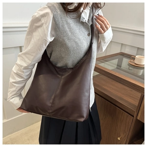 Dettaglio della borsa hobo marrone scuro con cuciture verticali su una modella