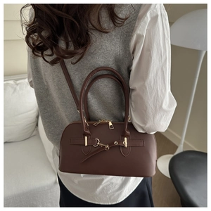 Detail einer dunkelbraunen Vintage-Boston-Tasche, die über der Schulter getragen wird