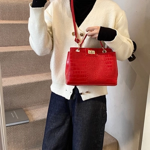 Minimalist red crocodile pattern crossbody handbag with adjustable strap shown on model