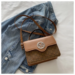 Detailed view of brown leather crossbody bag featuring M logo and patterned monogram