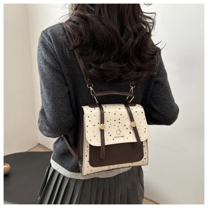 Close-up of retro two-tone backpack featuring colorful speckled patterns and leather straps