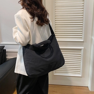 Large black minimalist tote bag for daily commute shown from a side view on a model