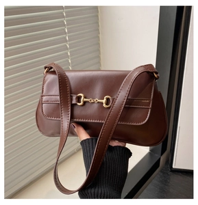 Détail du sac à bandoulière en cuir marron foncé avec boucle mors dorée de luxe