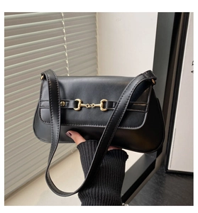 Détail du sac à main en cuir noir mat avec boucle mors dorée et bandoulière fine