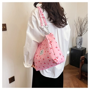 Pink tote bag with cherry print featuring chain straps and square logo patch on front