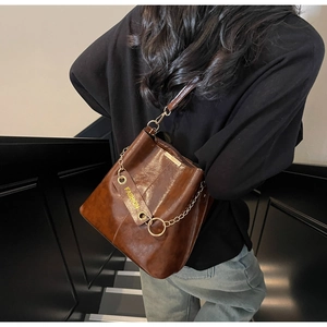 Brown vintage PU leather bucket bag detail with gold chain and fashion leather tag