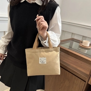 Minimalist beige canvas bucket bag with cute bear patch, stylish handheld tote for women