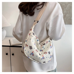 Detail of white pleated tote bag with colorful cartoon elephant patterns on adjustable strap