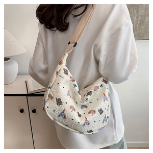 Detail of the white quilted fabric shoulder bag featuring cute elephant and bow patterns