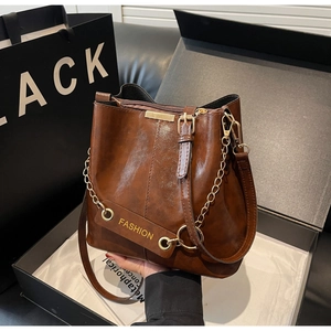 Detailed view of brown retro bucket bag with gold chain strap and elegant gift packaging