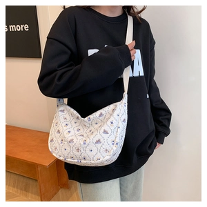 Close-up of quilted floral bear print on white canvas tote with wide shoulder strap