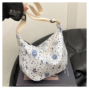 Detail of white quilted tote bag featuring blue bow and cartoon bear print patterns