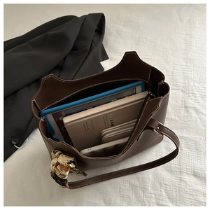 Macro shot of large dark brown tote bag interior with white stitching and silk scarf detail